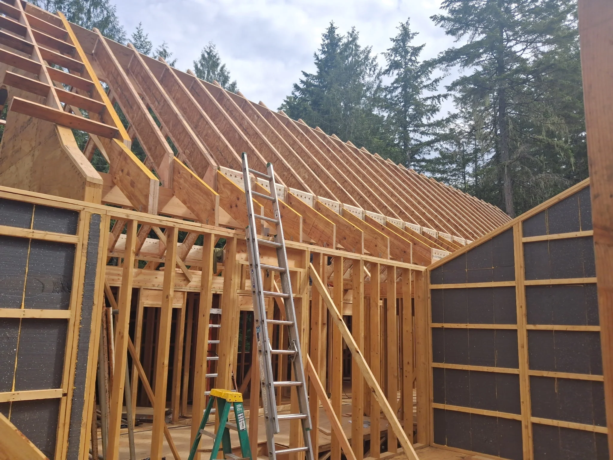 interior-timber-roof-framing-custom-home Interior timber roof framing under construction on a custom Tamlin home package.