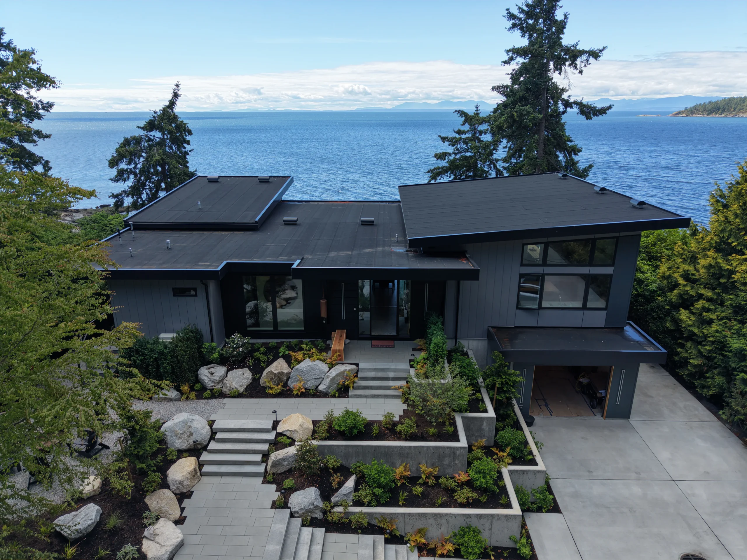 Aerial site view of a modern Sunshine Coast waterfront custom home integrated into coastal landscaping.